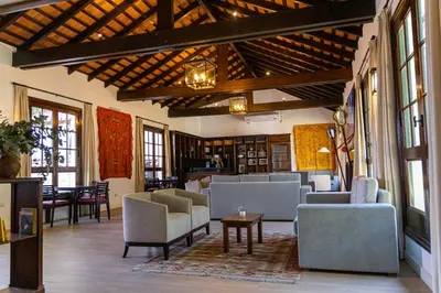 a living room with couches and chairs and a table at Hotel El Potrerillo de Larreta in Alta Gracia