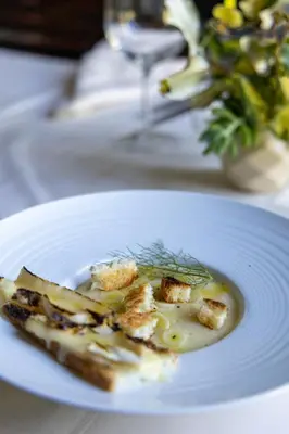 a white plate with a piece of food on a table at Hotel El Potrerillo de Larreta in Alta Gracia