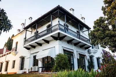 a white house with a balcony on top of it at Hotel El Potrerillo de Larreta in Alta Gracia