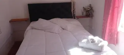 a white bed with white sheets and pillows on it at Tierra de Mariposas in Alta Gracia
