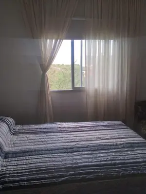 a bedroom with a large bed with a window at vistas del valle in Villa Carlos Paz