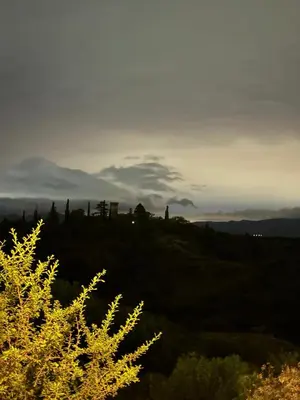 a sunset over a hill with a tree in the foreground at vistas del valle in Villa Carlos Paz