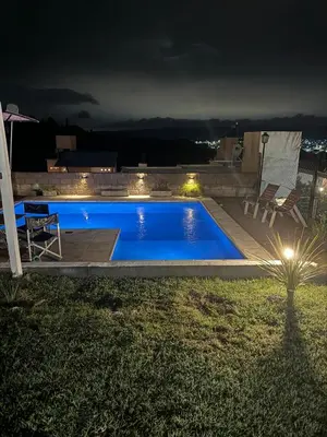 a swimming pool in a backyard at night at vistas del valle in Villa Carlos Paz