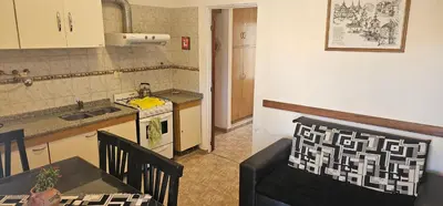 a kitchen with a sink and a table with a chair at Departamento Las Playas in Villa Carlos Paz