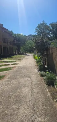 an empty road with a fence and a tree at Departamento Las Playas in Villa Carlos Paz