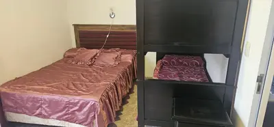 a small bedroom with a bed and a black cabinet at Departamento Las Playas in Villa Carlos Paz