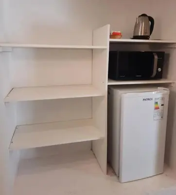 a kitchen with a white refrigerator and a microwave at Apart Centro Zazu in Mina Clavero