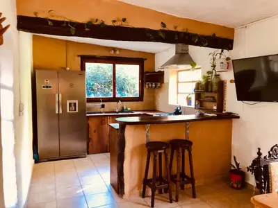 a kitchen with a refrigerator and two bar stools at Algarrobo del Valle in San Javier