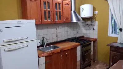 a kitchen with a white refrigerator and a sink at Casa Milan in Villa General Belgrano
