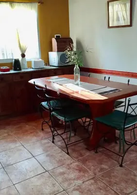 a table with chairs and a vase on top of it at Casa Milan in Villa General Belgrano