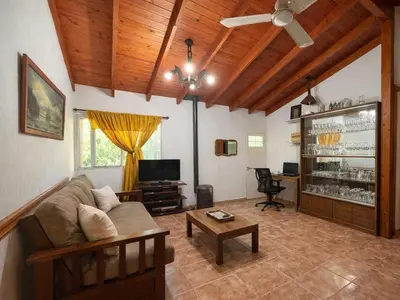 a living room with a couch and a tv at Casa Milan in Villa General Belgrano