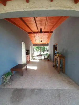 a living room with a wooden ceiling and a table at Casa Milan in Villa General Belgrano