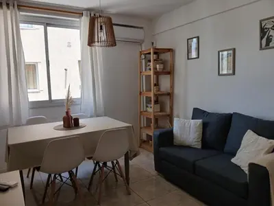 a living room with a table and a blue couch at Depto en Barrio General Paz in Cordoba
