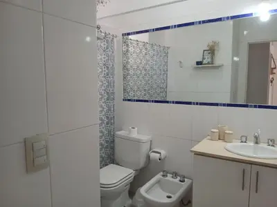 a white bathroom with a toilet and a sink at Depto en Barrio General Paz in Cordoba