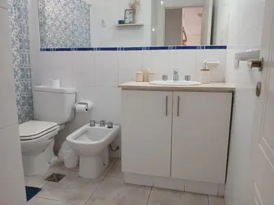 a white bathroom with a toilet and a sink at Depto en Barrio General Paz in Cordoba