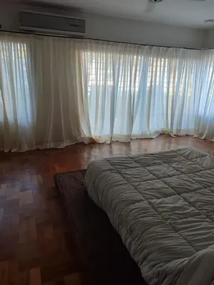 a bedroom with a large bed and white curtains at The House you're looking for in Cordoba