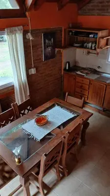 a kitchen with a wooden table in a room at Cabañas Lago Azul in Villa Santa Cruz del Lago