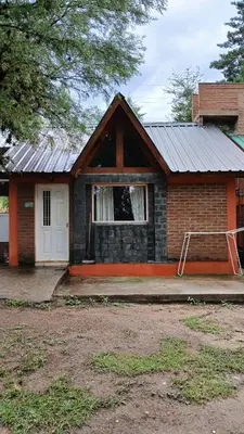 a small brick house with a white door at Cabañas Lago Azul in Villa Santa Cruz del Lago