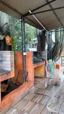 a patio with a table and chairs under a pavilion at Cabañas Lago Azul in Villa Santa Cruz del Lago