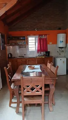 a wooden table and chairs in a kitchen at Cabañas Lago Azul in Villa Santa Cruz del Lago