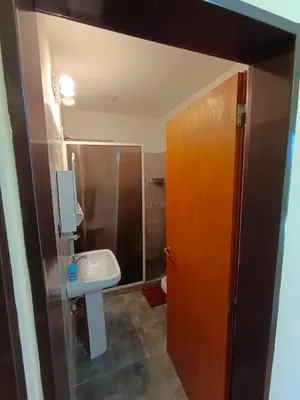 a bathroom with a sink and a toilet and a door at Duplex con vista al Lago in Villa Carlos Paz