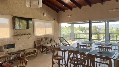 a restaurant with tables and chairs and a balcony at Duplex con vista al Lago in Villa Carlos Paz
