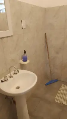 a bathroom with a sink and a blue vase on the wall at Departamento CR in Alta Gracia