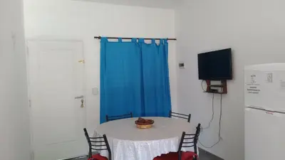 a room with a table with a blue curtain and a television at Departamento CR in Alta Gracia