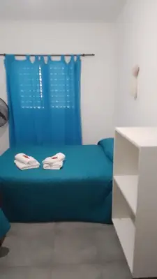a blue bed in a room with a blue curtain at Departamento CR in Alta Gracia
