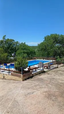 a swimming pool with a tree in front of it at Cabañas las marias 3 in Tanti Nuevo