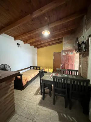 a room with a bed and a table and chairs at Cabañas las marias 3 in Tanti Nuevo