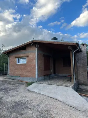 a brick building with a window and a roof at Cabañas las marias 3 in Tanti Nuevo