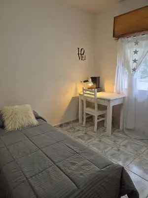 a bedroom with a bed and a desk and a table at Apartamento en Villa Carlos Paz in Villa Carlos Paz