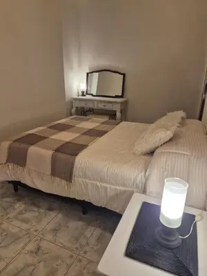 a bedroom with a bed and a table with a laptop at Apartamento en Villa Carlos Paz in Villa Carlos Paz
