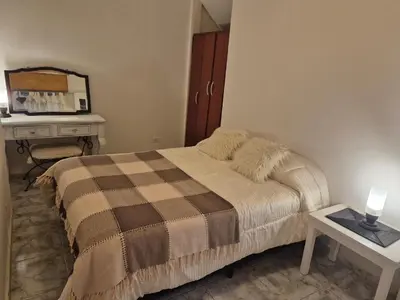 a small bedroom with a bed and a table at Apartamento en Villa Carlos Paz in Villa Carlos Paz