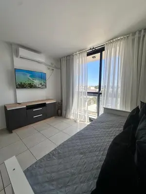 a bedroom with a large bed and a flat screen tv at Departamento Premium con hermosos atardeceres in Cordoba