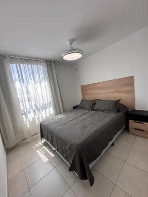 a bedroom with a bed and a large window at Departamento Premium con hermosos atardeceres in Cordoba
