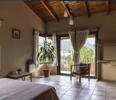 a bedroom with a bed and a large window at Mirian house in Villa Carlos Paz
