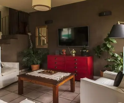 a living room with a red dresser and a tv at Mirian house in Villa Carlos Paz
