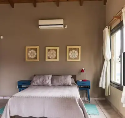 a bedroom with a bed and two tables and a window at Mirian house in Villa Carlos Paz