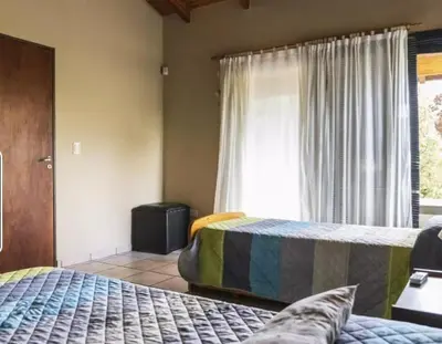 a bedroom with two beds and a window at Mirian house in Villa Carlos Paz
