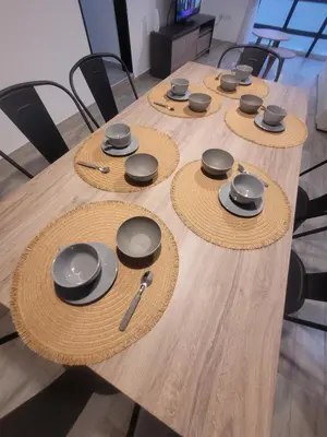 a wooden table with black chargers on top of it at Strategic place, close to everything in Villa Carlos Paz