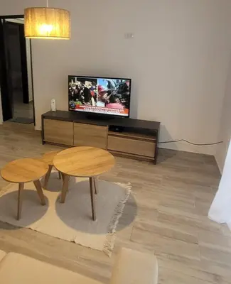a living room with a flat screen tv and two tables at Strategic place, close to everything in Villa Carlos Paz