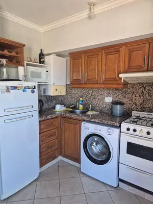a kitchen with a washing machine and a washer at LUMINOSO Y COMPLETO DEPARTAMENTO CENTRO Villa Carlos Paz in Villa Carlos Paz