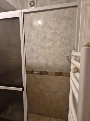 a shower with a glass door in a bathroom at LUMINOSO Y COMPLETO DEPARTAMENTO CENTRO Villa Carlos Paz in Villa Carlos Paz