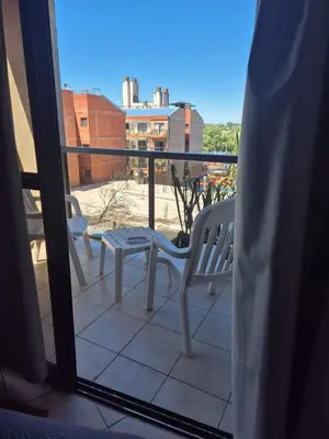 a balcony with two chairs and a table on a balcony at LUMINOSO Y COMPLETO DEPARTAMENTO CENTRO Villa Carlos Paz in Villa Carlos Paz