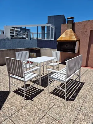 two chairs and a table and a table and a stove at LUMINOSO Y COMPLETO DEPARTAMENTO CENTRO Villa Carlos Paz in Villa Carlos Paz