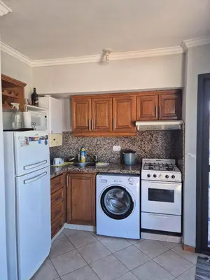 a kitchen with a white stove and a dishwasher at LUMINOSO Y COMPLETO DEPARTAMENTO CENTRO Villa Carlos Paz in Villa Carlos Paz
