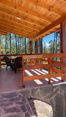 a wooden pavilion with two chairs and a table at Cabañas Aldea Lucerna La Cumbrecita in La Cumbrecita
