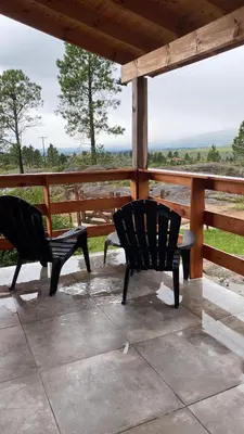 two chairs sitting on a porch with a view at Cabañas Aldea Lucerna La Cumbrecita in La Cumbrecita